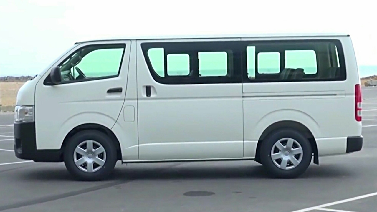 A White Toyota HiAce Tourist Van parked in Rwanda, used for group travel and safari hire